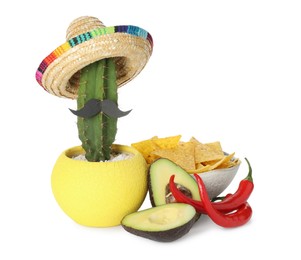 Photo of Cactus with Mexican sombrero hat, fake mustache, chili peppers, cut avocado and nachos chips in bowl isolated on white