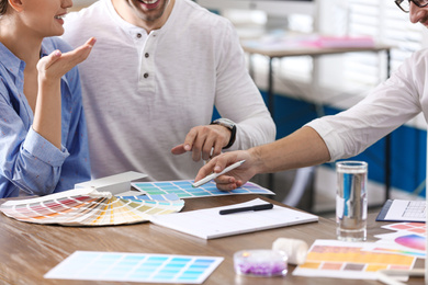 Photo of Interior designer consulting young couple in office, closeup