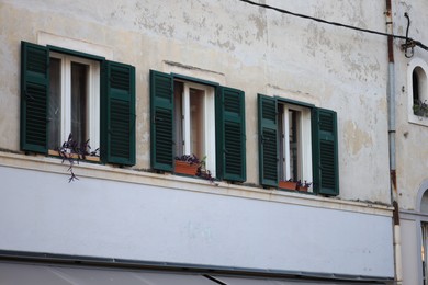 Photo of Old residential building with windows and wooden shutters