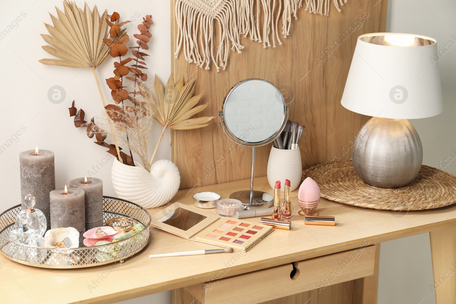 Photo of Dressing table with mirror, makeup products and decor in room