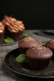 Photo of Delicious chocolate muffins served on grey table, closeup