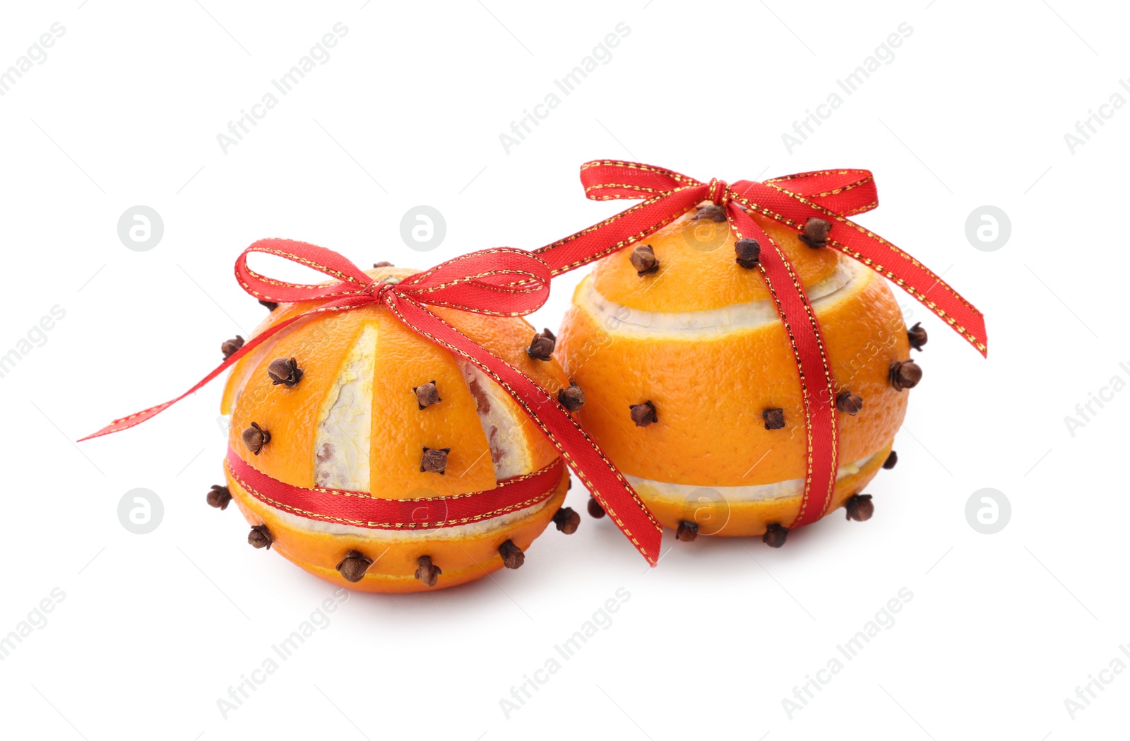 Photo of Pomander balls with red ribbons made of fresh tangerines and cloves on white background