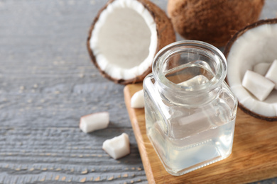 Photo of Coconut oil on grey wooden table, closeup, space for text