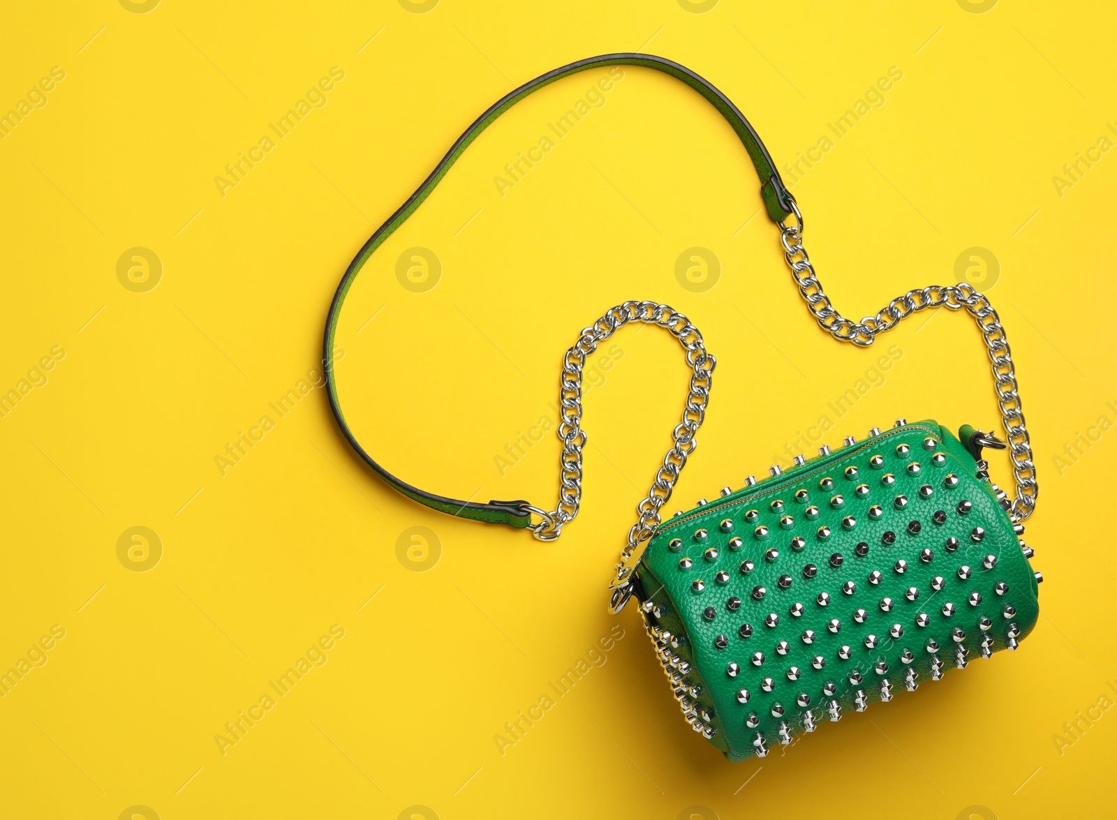 Photo of Stylish woman's bag on yellow background, top view