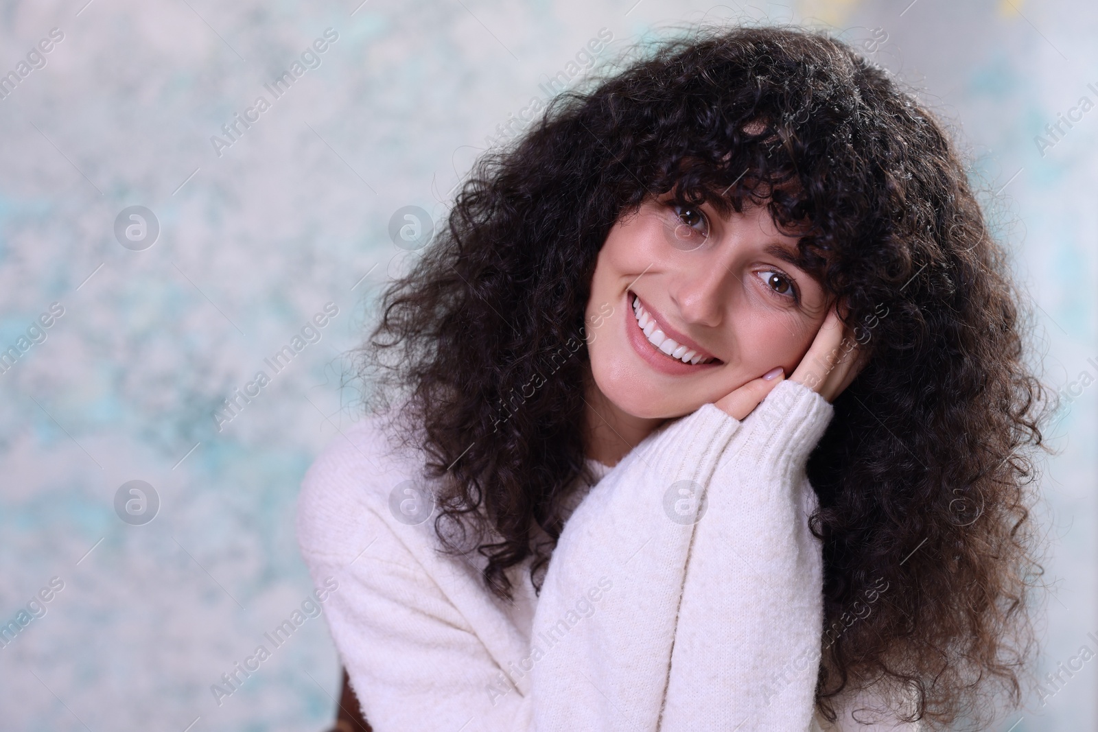 Photo of Portrait of happy young woman in stylish sweater on color background