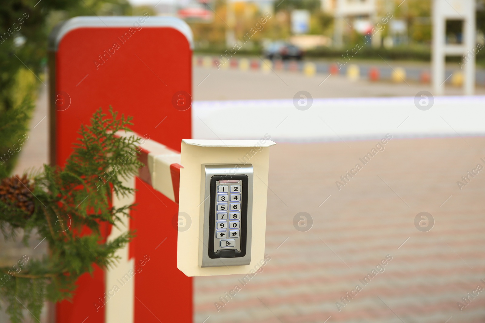 Photo of Closeup view of closed automatic boom barrier with control panel outdoors, space for text