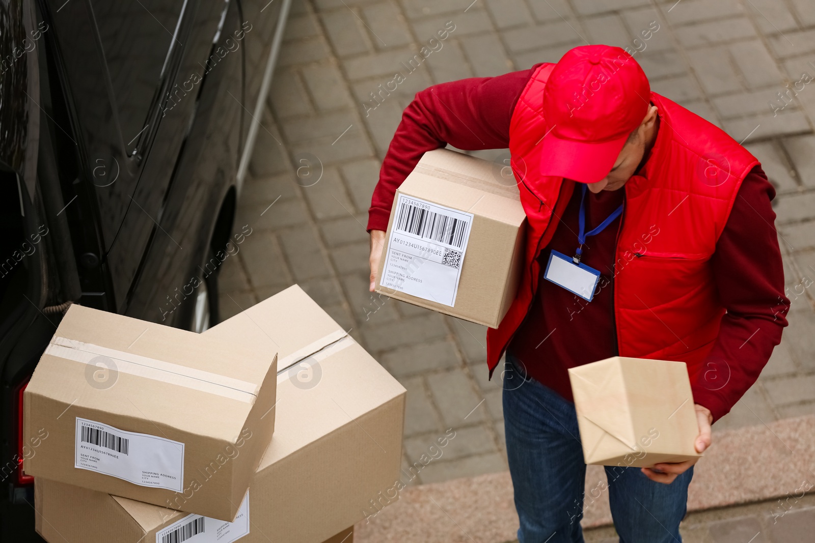 Photo of Courier with parcels near delivery van outdoors, above view