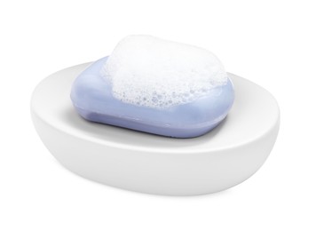 Soap bar with fluffy foam in holder on white background