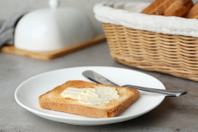 Photo of Slice of toasted bread with butter on grey table