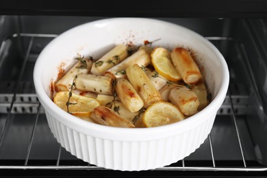 Photo of Dish with baked salsify roots, lemon and thyme in oven