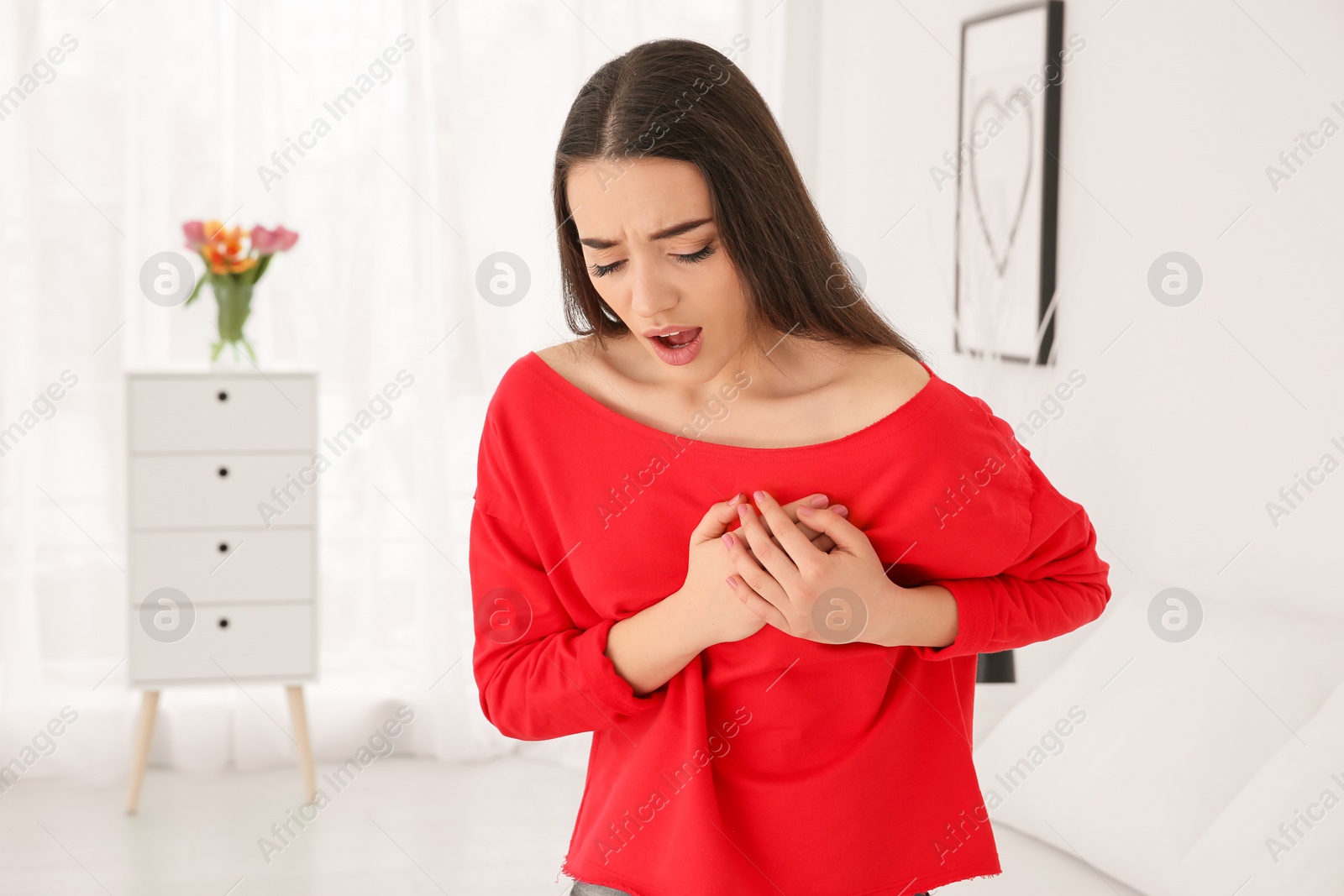 Photo of Young woman suffering from heart attack at home