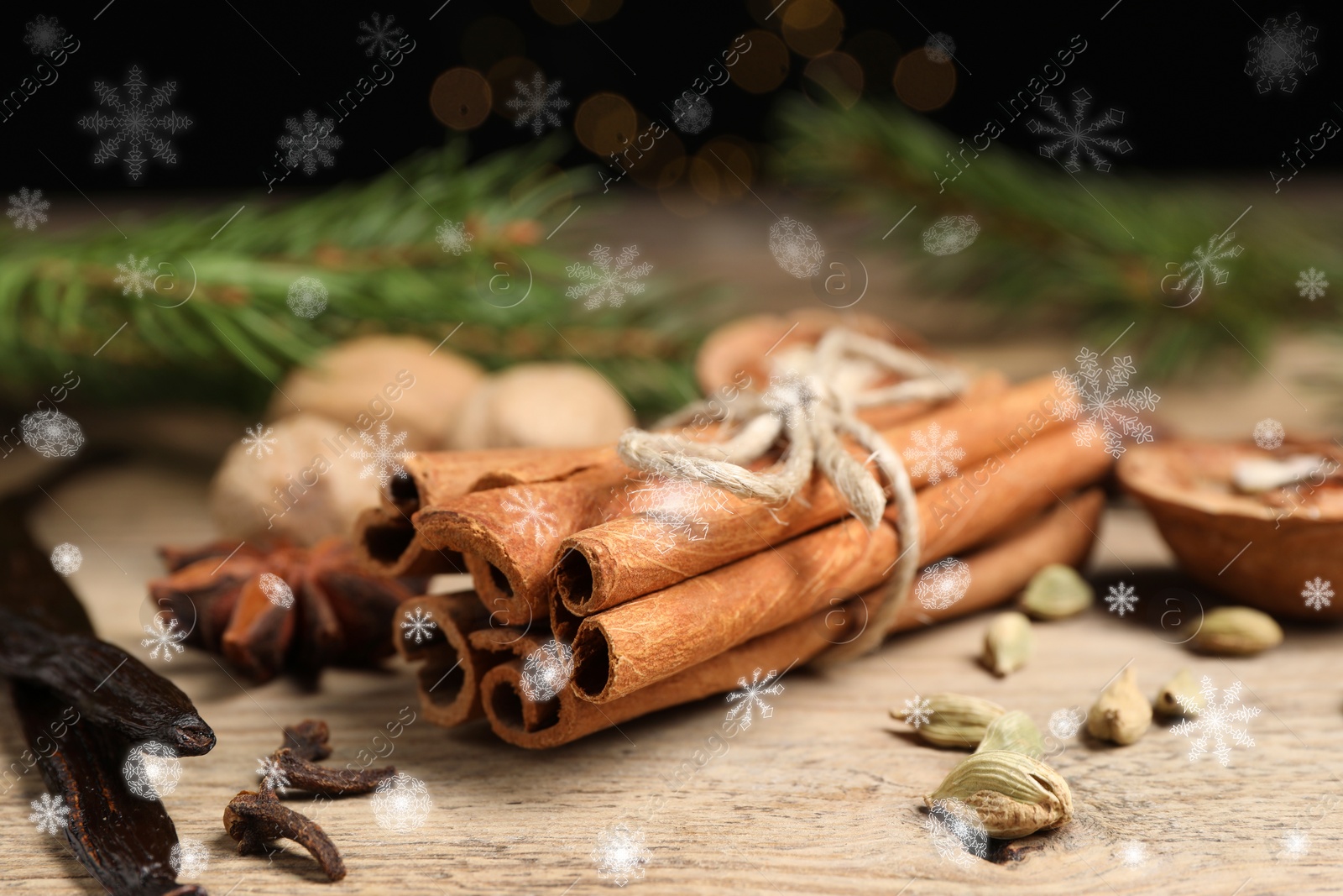 Image of Different spices and fir tree branches on wooden table, closeup. Cinnamon, cloves, anise, cardamom, vanilla, nutmegs