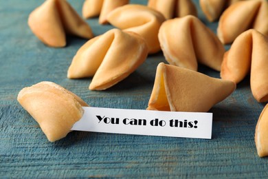 Tasty fortune cookie with prediction You can do this! on blue wooden table, closeup