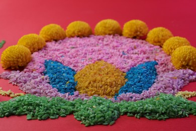 Happy Diwali. Composition with colorful rangoli and chrysanthemum flowers on red background, closeup