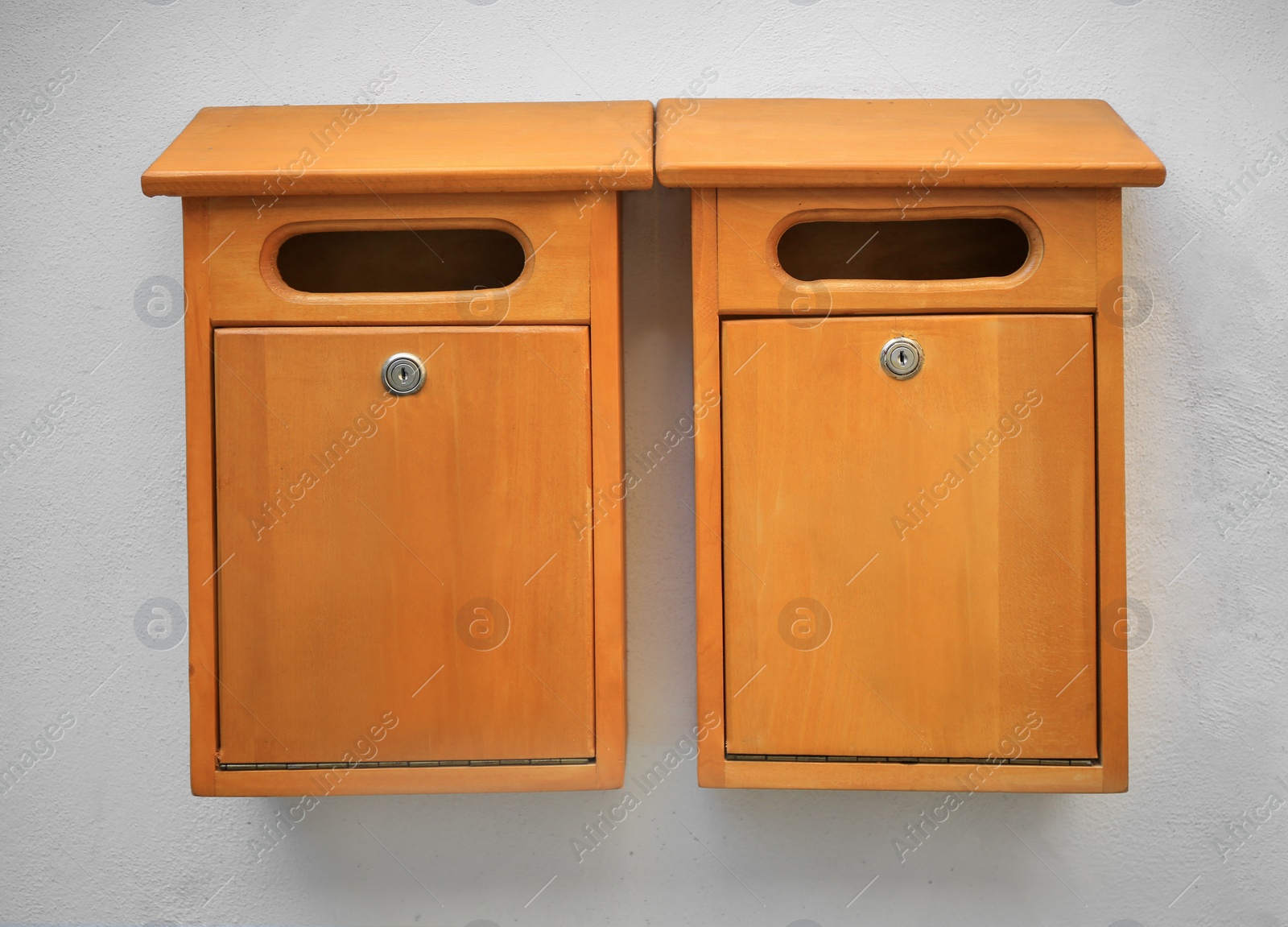 Photo of Orange wooden letter boxes on white wall