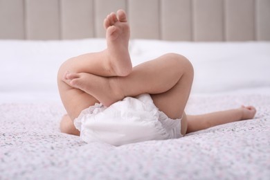 Little baby in diaper on bed, closeup