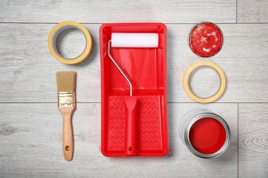 Photo of Flat lay composition with can of paint and decorator tools on wooden background