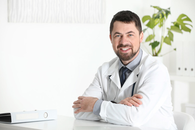 Photo of Portrait of male doctor in white coat at workplace