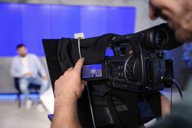 Photo of Professional video camera operator working in studio, closeup