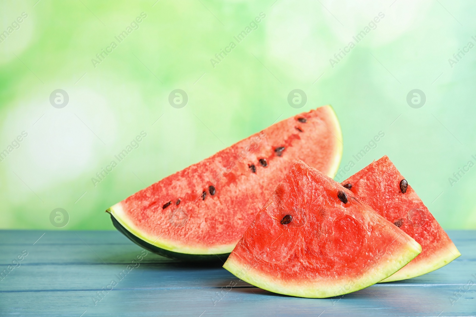 Photo of Fresh juicy watermelon with seeds on wooden table