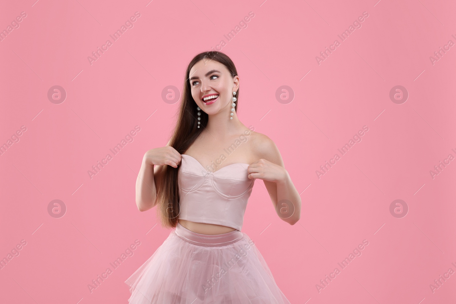 Photo of Beautiful woman in pale pink clothes on color background