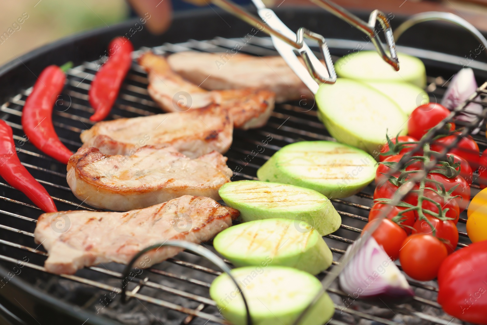 Photo of Modern grill with meat and vegetables outdoors, closeup