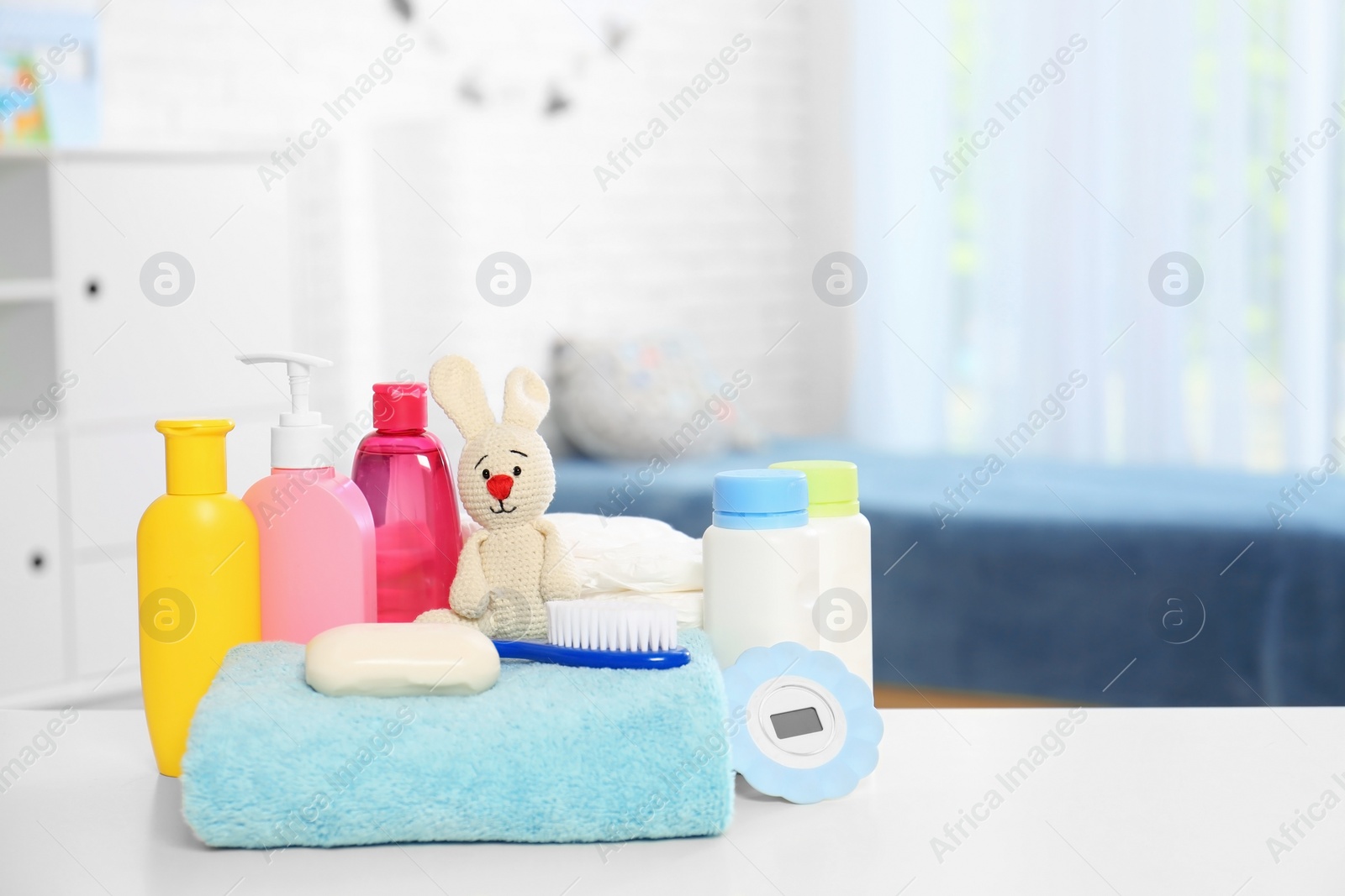Photo of Baby accessories on table in nursery room. Space for text