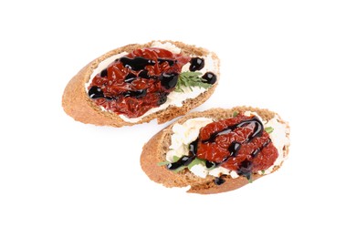 Photo of Delicious bruschettas with sun-dried tomatoes, cream cheese and balsamic vinegar isolated on white, top view