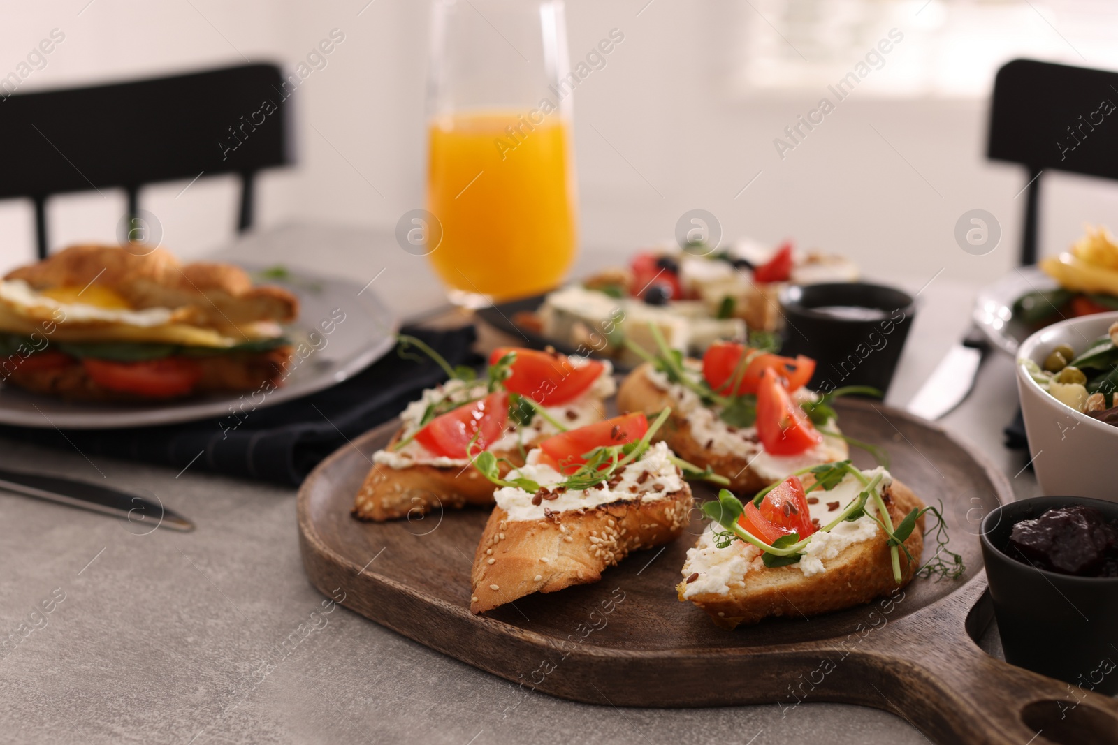 Photo of Delicious sandwiches with cheese and tomatoes served on buffet table for brunch