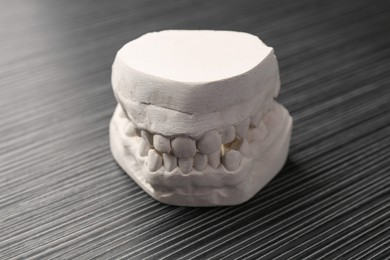 Dental model with gums on grey wooden table. Cast of teeth