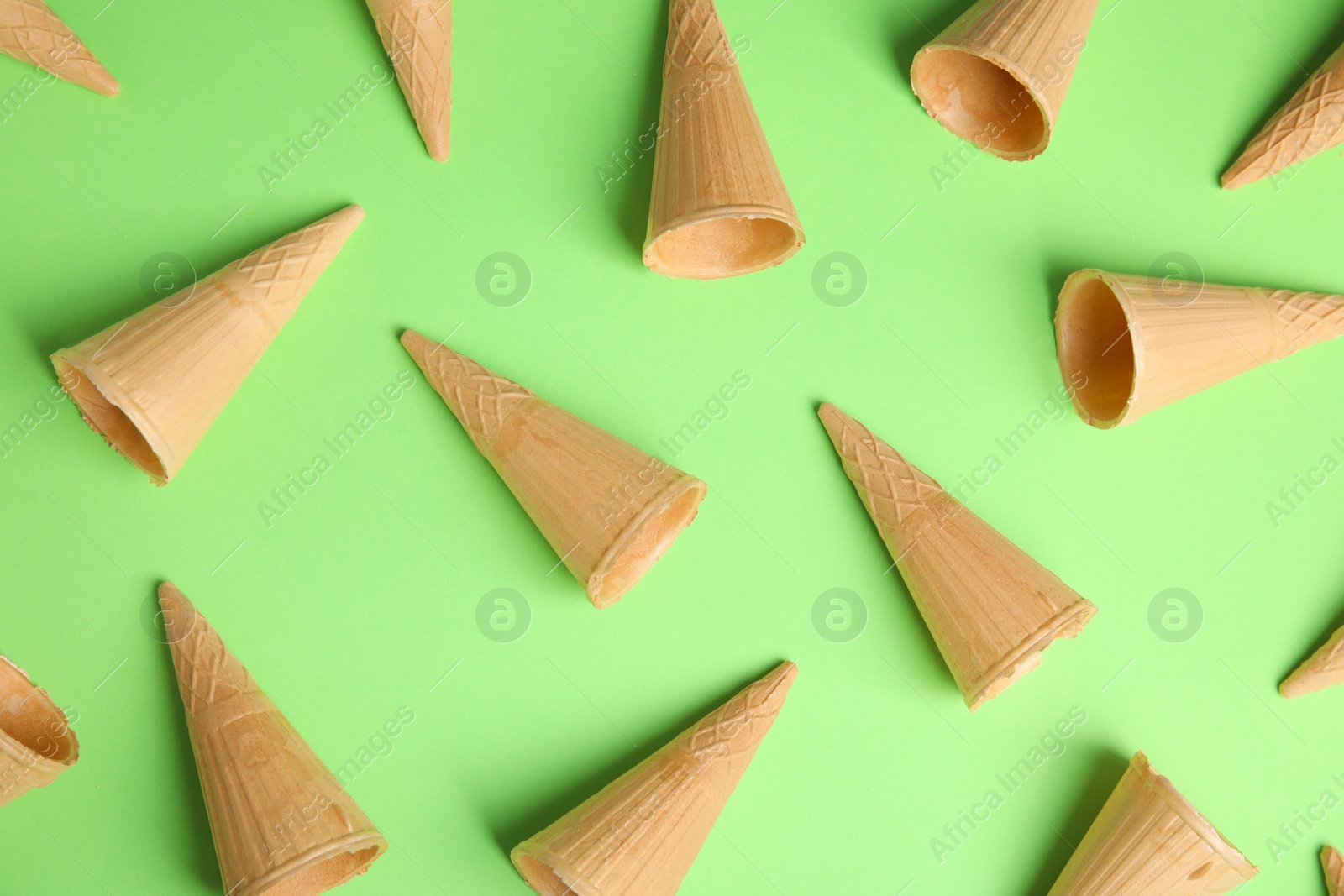 Photo of Waffle empty ice cream cones on color background, flat lay