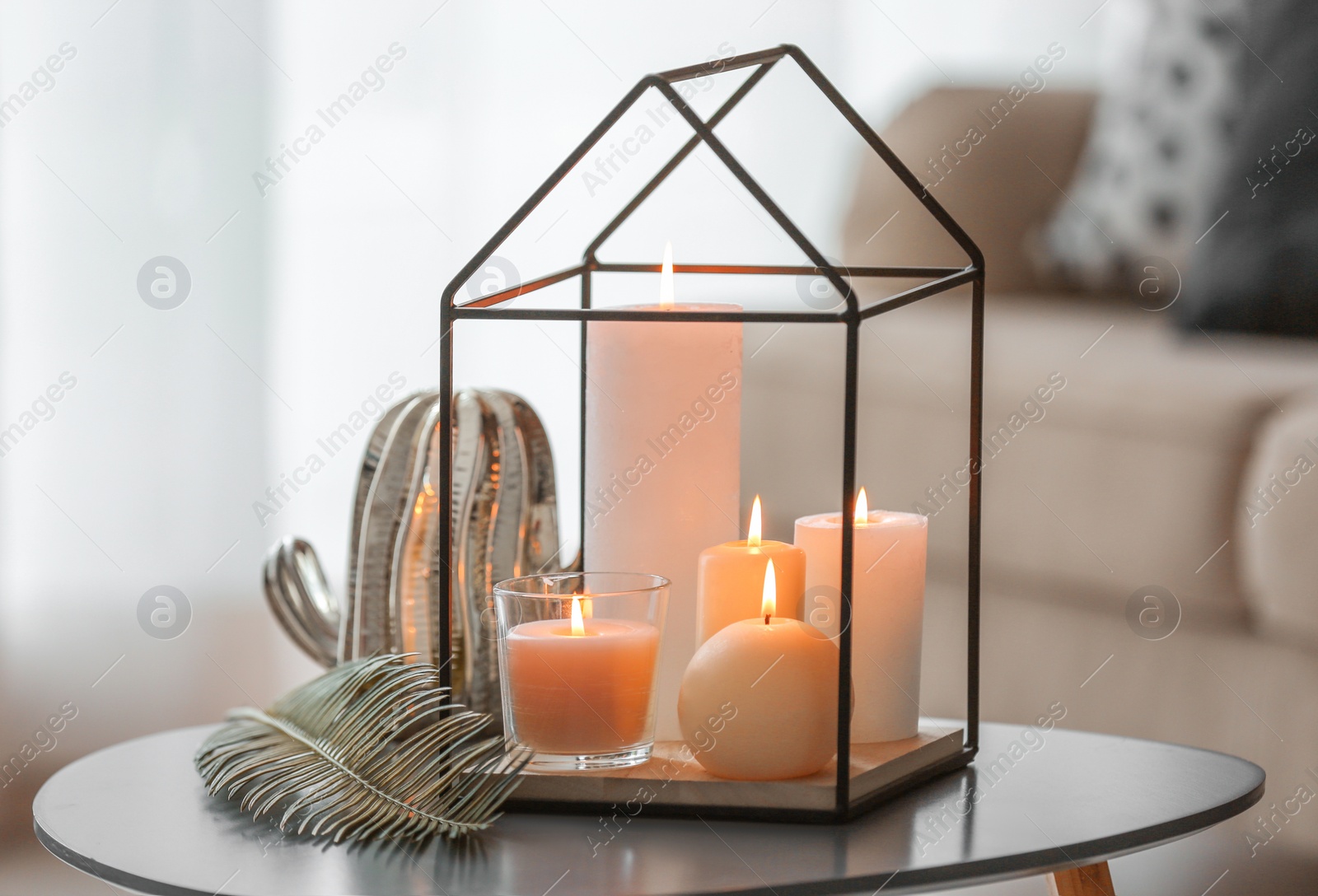 Photo of Burning candles on table against blurred background