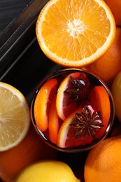 Glass of aromatic punch drink and fresh citrus fruits on table, flat lay