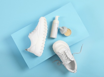 Photo of Stylish footwear and shoe care accessories on light blue background, flat lay