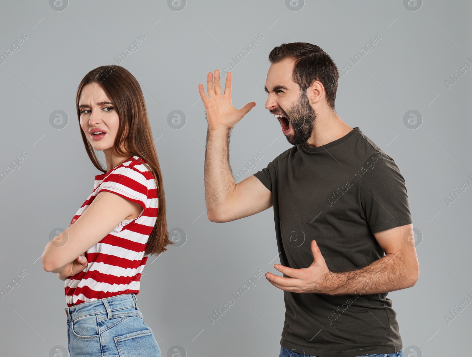 Photo of Man shouting at his girlfriend on grey background. Relationship problems