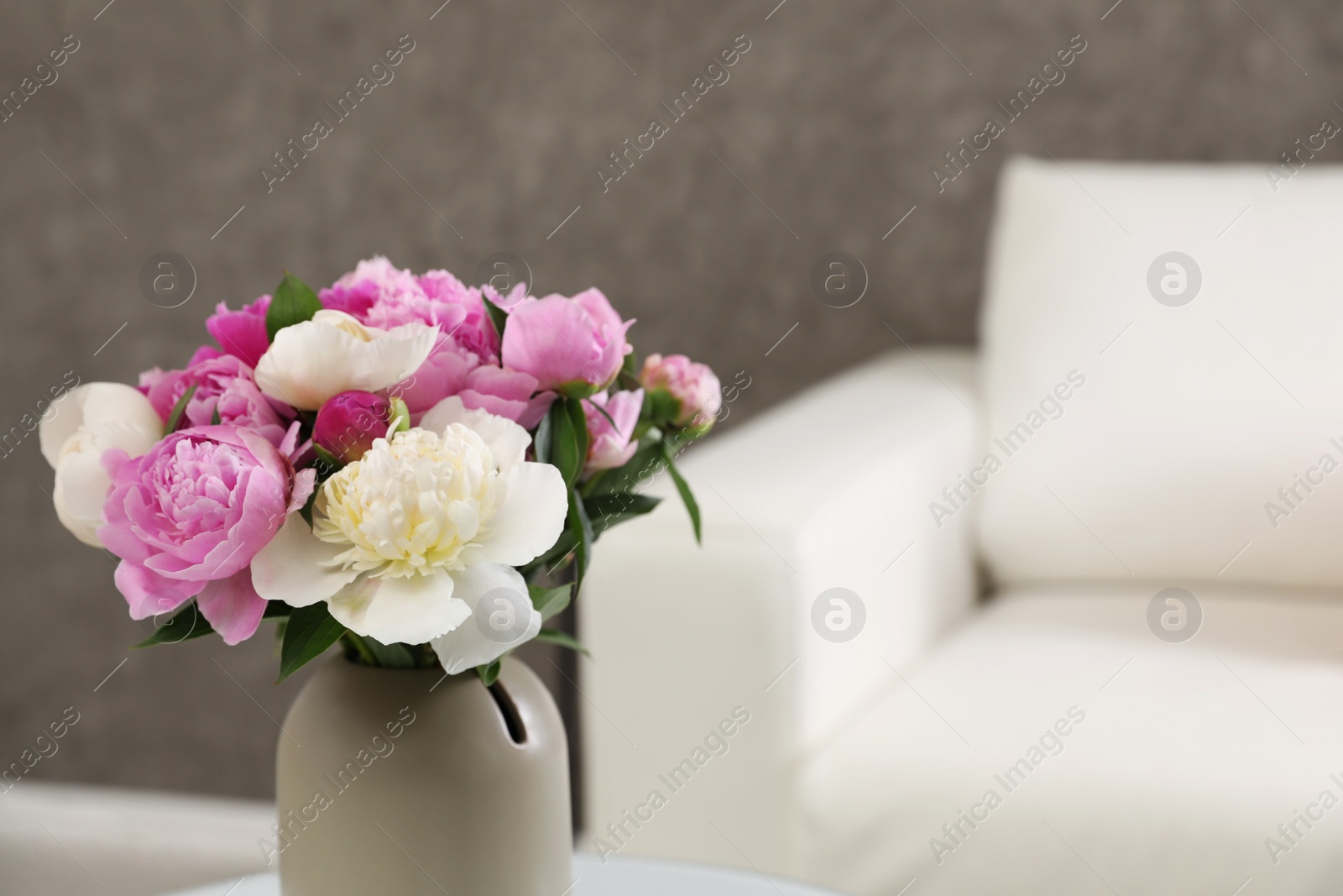 Photo of Vase with bouquet of beautiful peonies in room, space for text