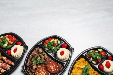 Photo of Top view of lunchboxes with different meals on white table, space for text. Healthy food delivery