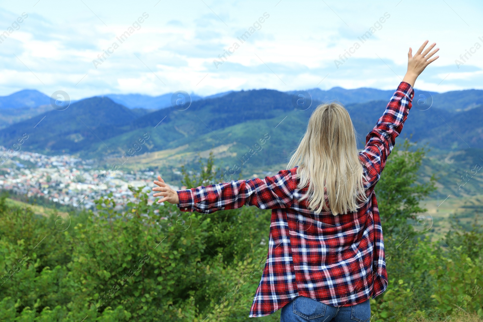 Photo of Woman enjoying beautiful mountain landscape, back view