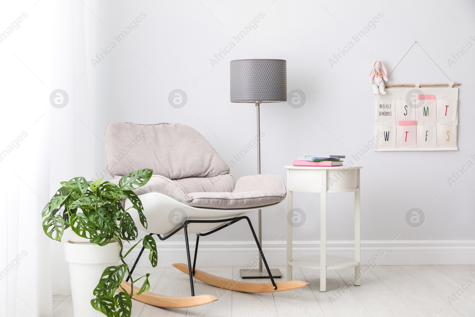 Photo of Stylish child room interior with comfortable rocking chair