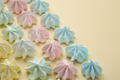 Photo of Delicious meringue cookies on beige background, closeup. Space for text