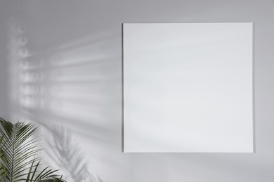 Photo of Blank canvas on light grey wall indoors. Space for design