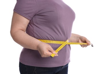 Photo of Overweight woman measuring waist with tape on white background, closeup