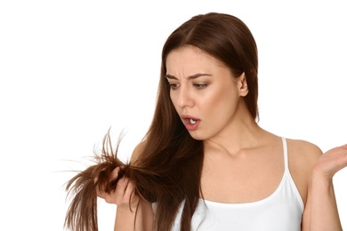 Photo of Emotional woman with damaged hair on white background. Split ends