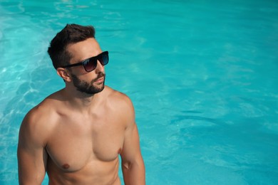 Handsome man in outdoor swimming pool on sunny summer day