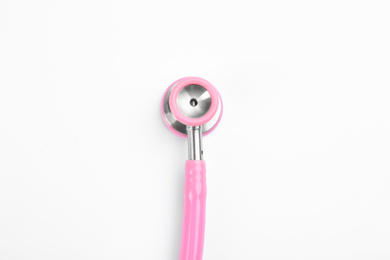 Pink stethoscope isolated on white, top view. Breast cancer awareness