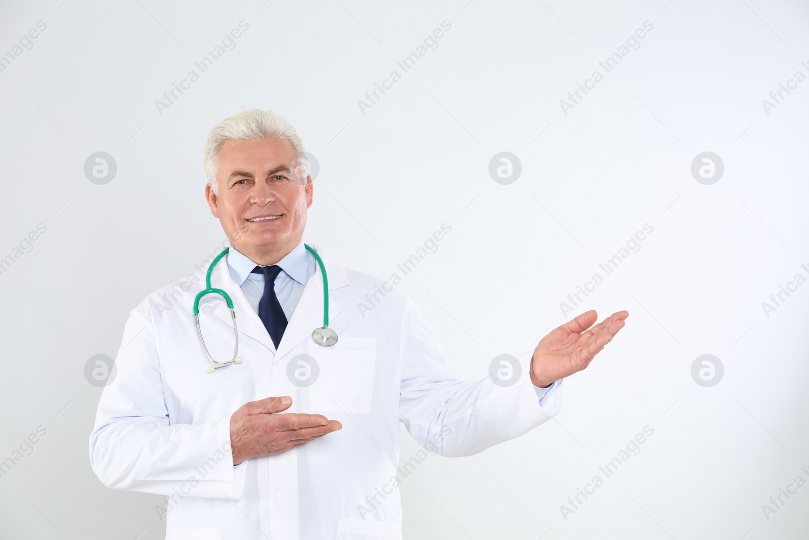 Photo of Portrait of senior doctor with stethoscope on white background