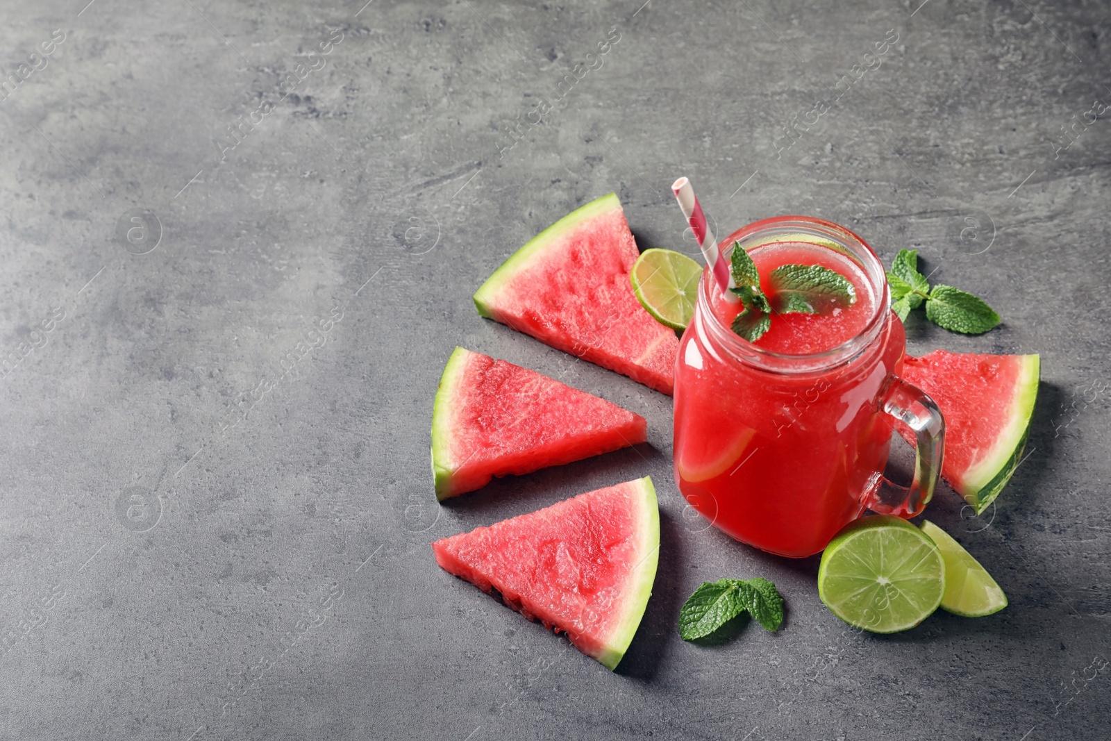 Photo of Summer watermelon drink in mason jar, sliced fruits and space for text on table