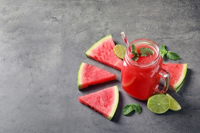 Summer watermelon drink in mason jar, sliced fruits and space for text on table