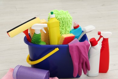 Photo of Different cleaning supplies in bucket on floor