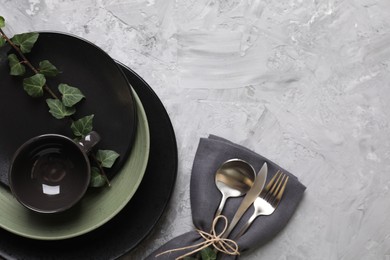 Photo of Stylish table setting. Dishes, cutlery, napkin and floral decor, top view with space for text